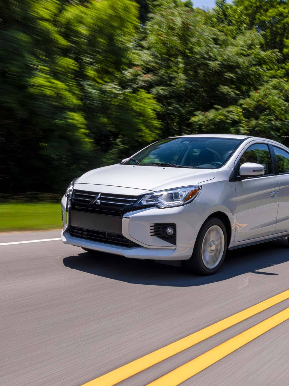 A white 2024 Mitsubishi Mirage G4 Sedan driving on the road