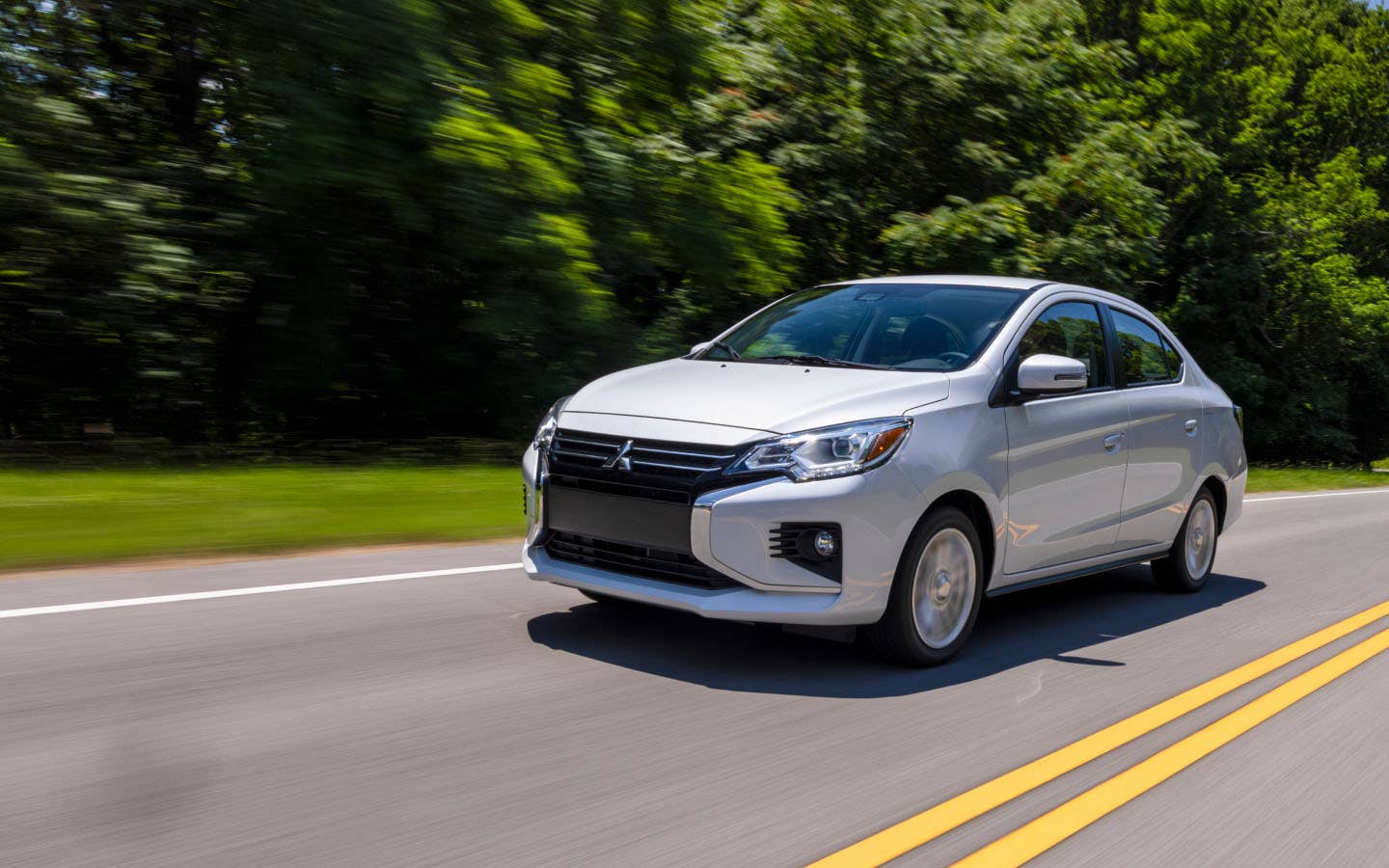 A white 2024 Mitsubishi Mirage G4 Sedan driving on the road