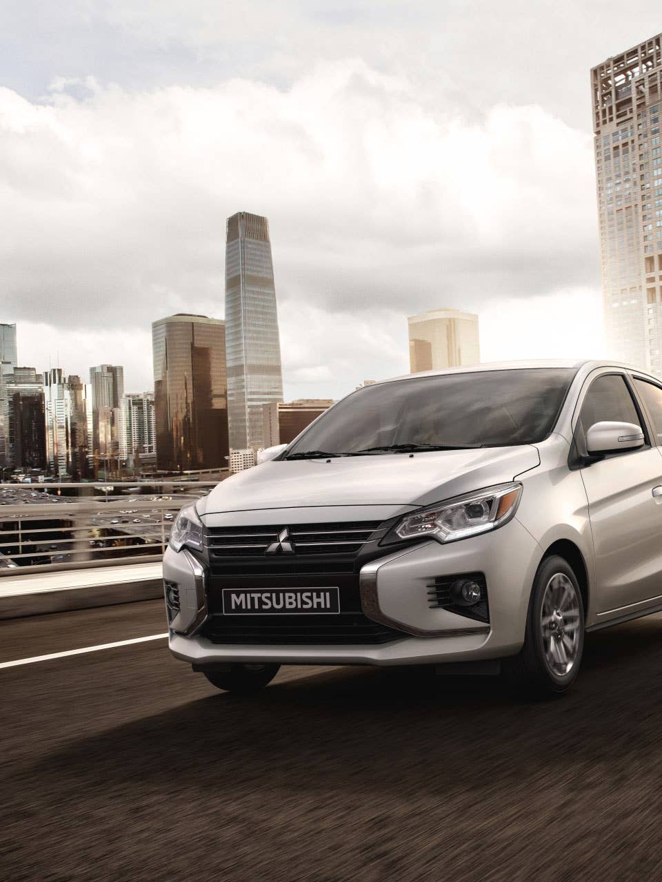 A silver 2024 Mitsubishi Mirage G4 Sedan driving in the city