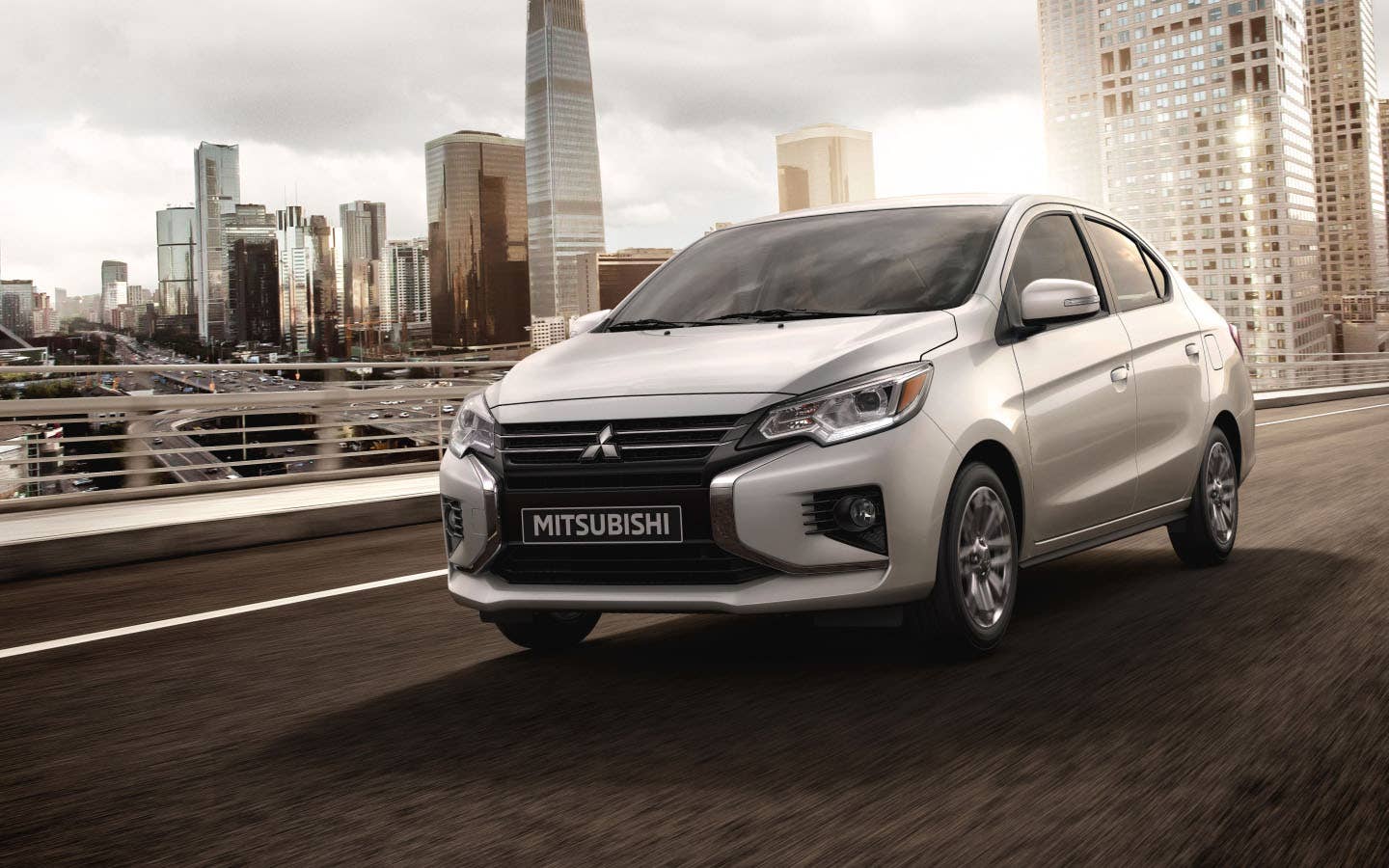 A silver 2024 Mitsubishi Mirage G4 Sedan driving in the city