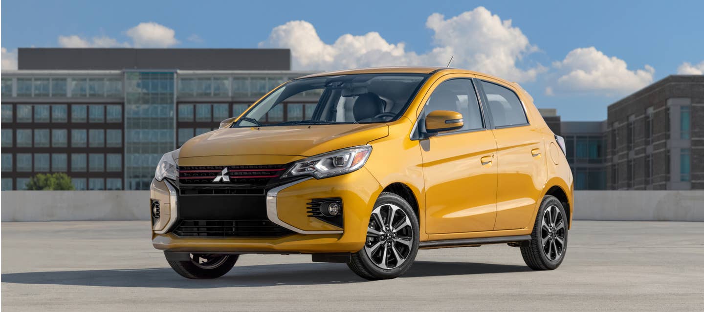 Yellow 2024 Mitsubishi Mirage Compact Hatchback parked in front of some buildings
