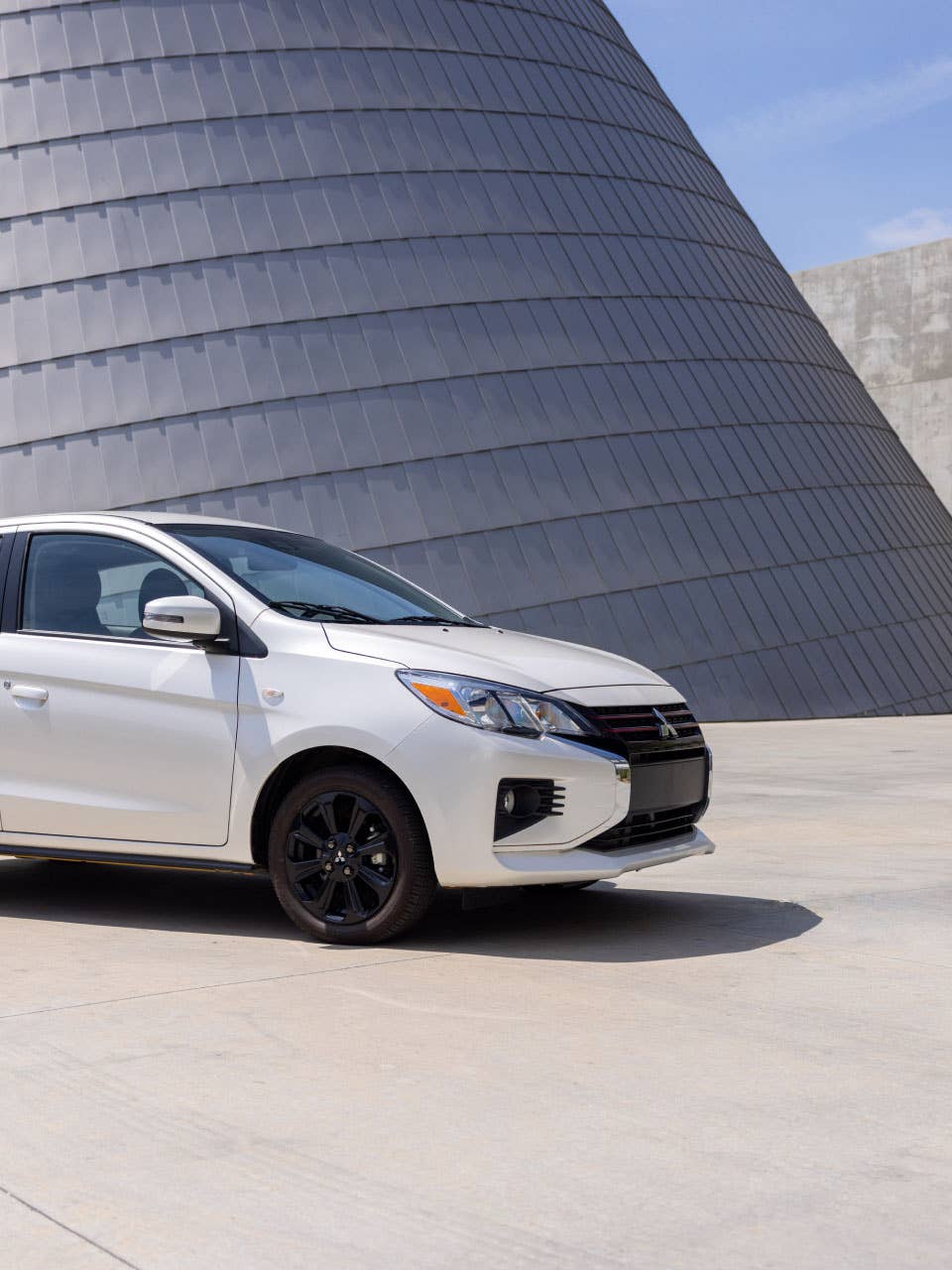 Angled side view of a white 2024 Mitsubishi Mirage Compact Hatchback