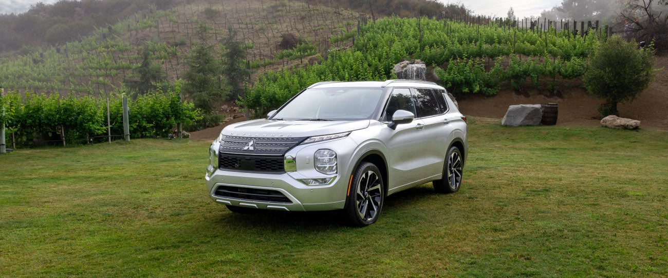 Angled view of a silver 2024 Mitsubishi Outlander SUV parked