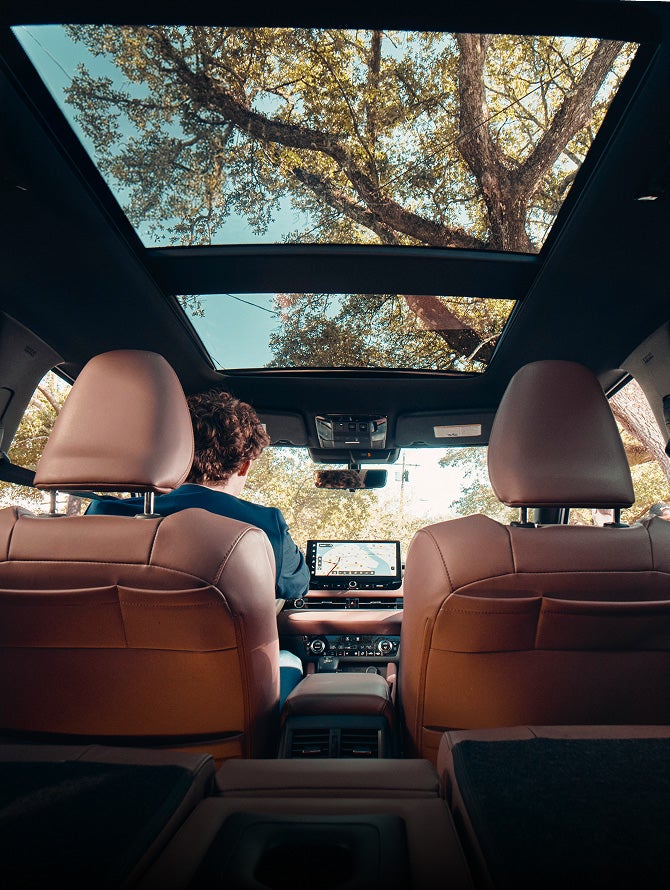 Vista desde el asiento trasero de la SUV Mitsubishi Outlander 2026 con techo panorámico eléctrico.