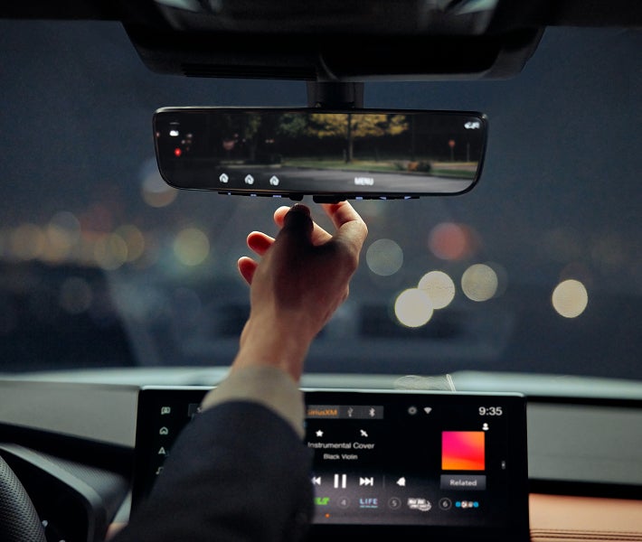 Primer plano del espejo retrovisor de la Mitsubishi Outlander 2026 mostrando la integración Homelink para apertura de garaje.